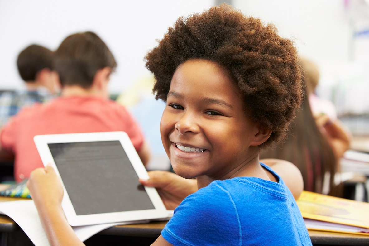 Young child holding a tablet and smiling