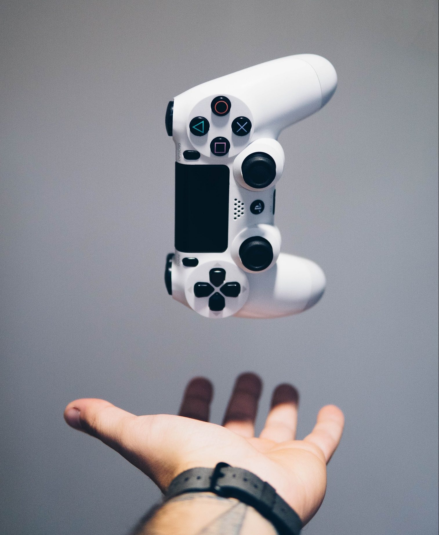 Video game controller being dropped into the palm of a hand