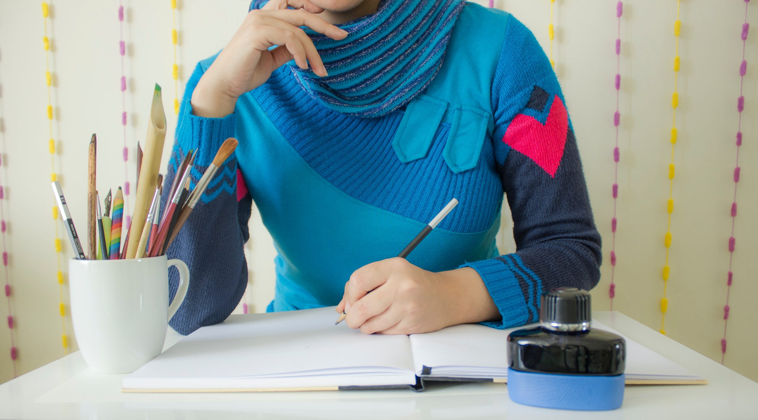 A Women writing Authoring Services on Notebook with pencil