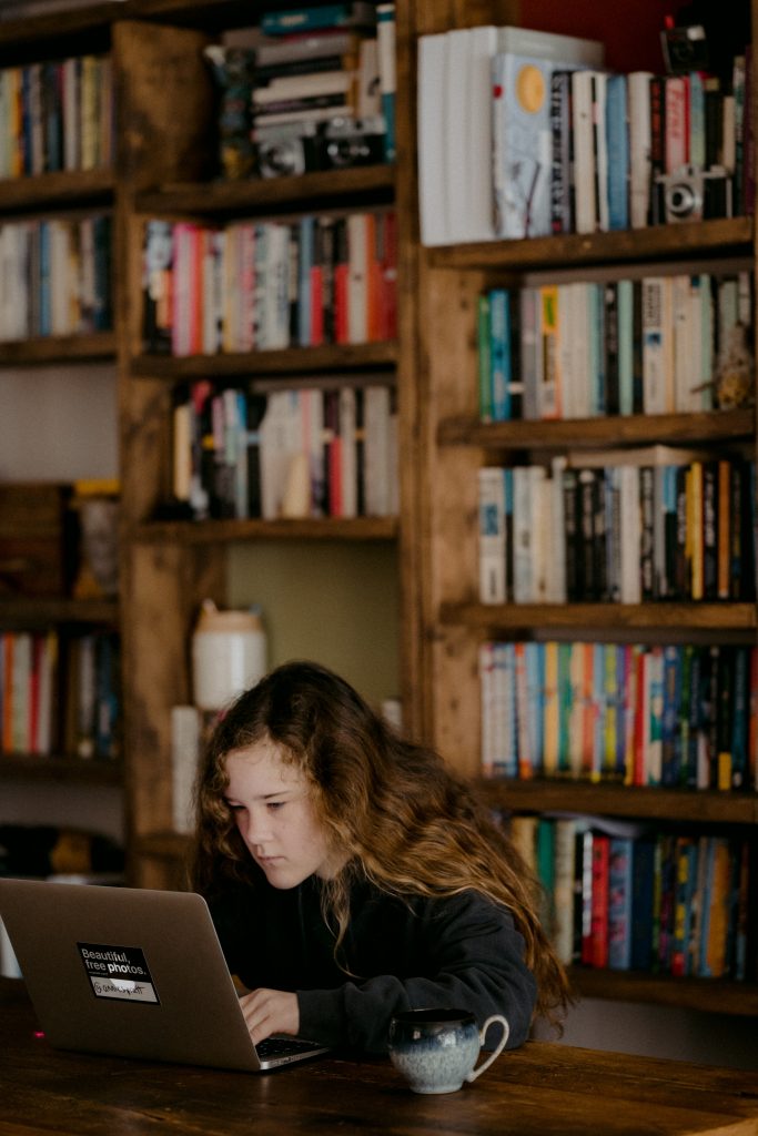 Person sitting at a table working on a laptop.