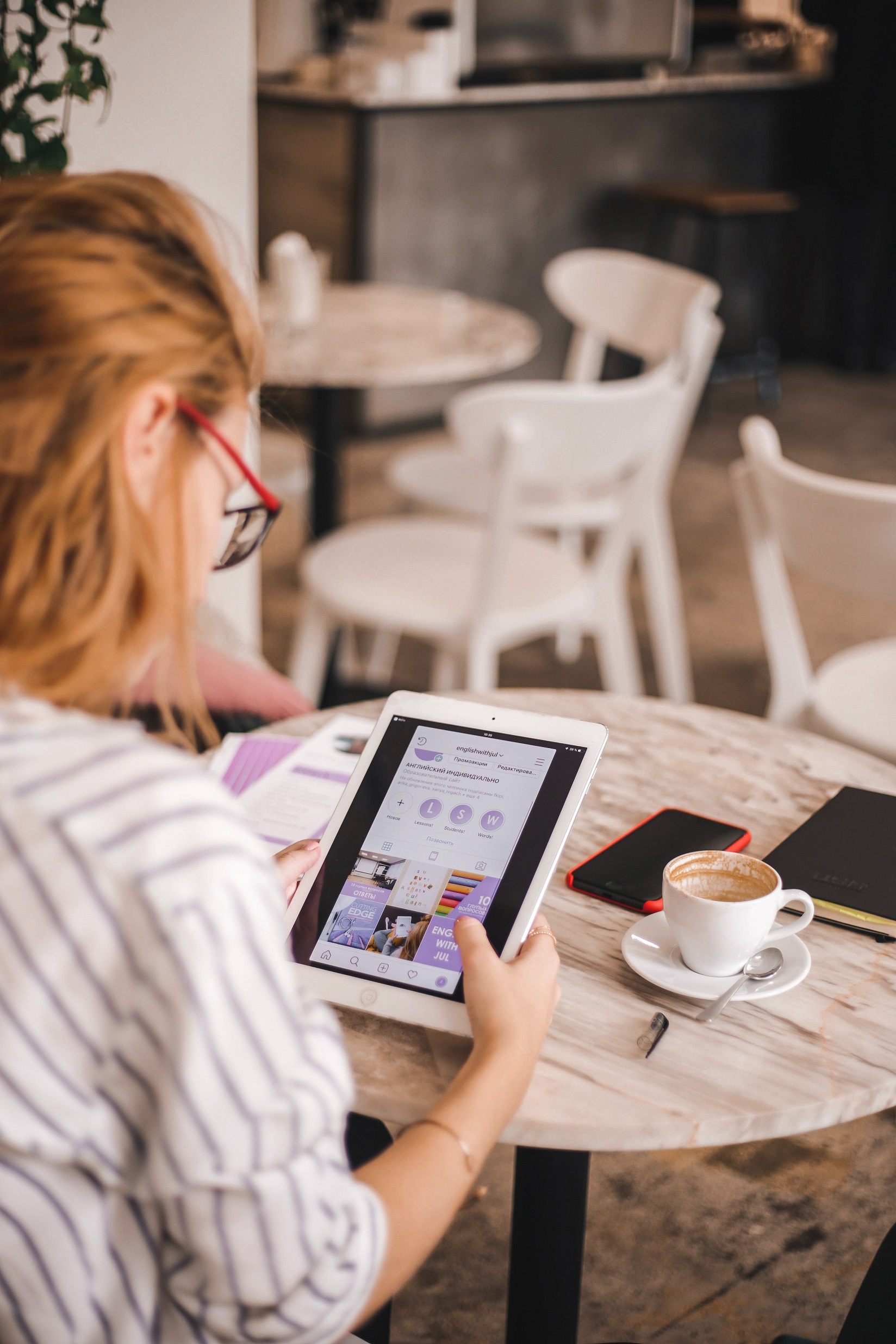 Person sitting at a table looking at a tablet