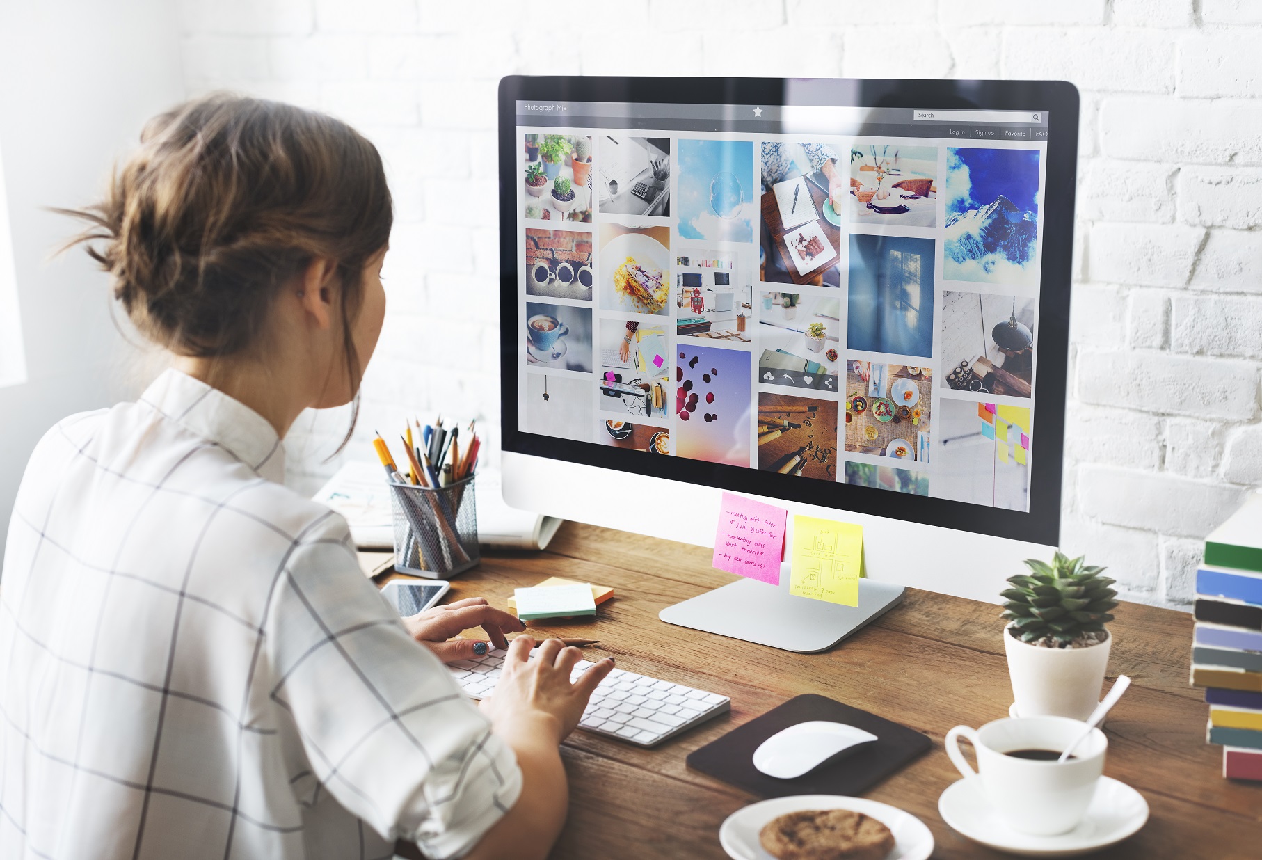 Person sitting at a computer looking at rows of photographs on the monitor