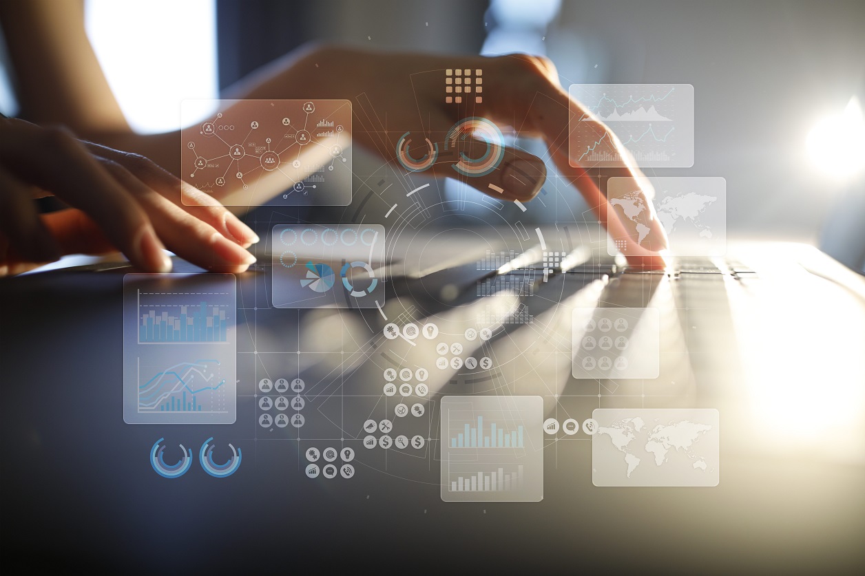 A person's hands with transparent overlay images of different types of data, graphs, and charts.