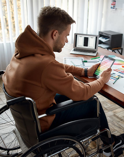 Person sitting at a desk while looking at a tablet